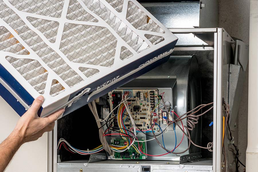 Technician replacing an air filter in a furnace