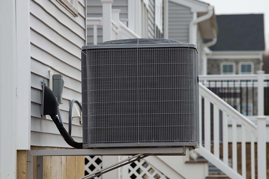 Outdoor residential air conditioning condenser unit mounted beside a home, illustrating routine AC maintenance and system care to improve efficiency and prevent costly breakdowns in Humble, TX.